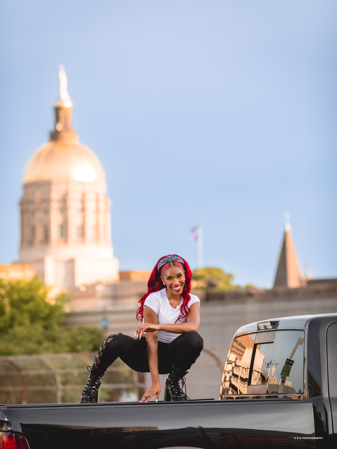 Madaí Chakell posed on a truck with city architecture behind her